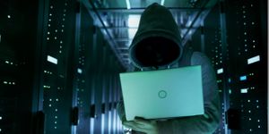 Close-up shot of hacker in a data center full of rack servers