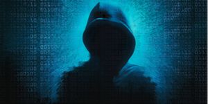 image of a person in a hooded shirt sitting in dark room depicting dark and deep web