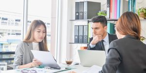 A male CIO in a meeting discussing IT targets with 2 female team members