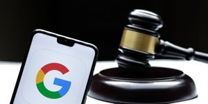 Google Logo on Smartphone With Gavel in Background