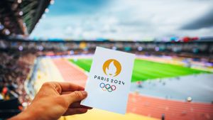 Image showing a sports fan holding Paris Olympics card
