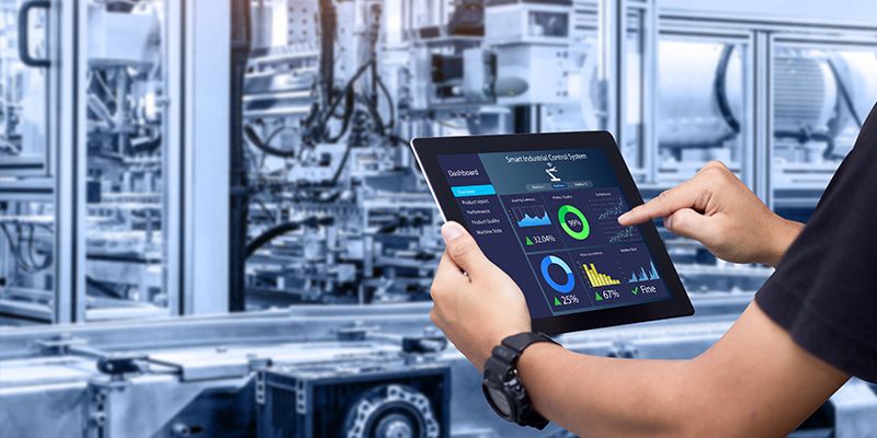 Smart industry control concept. Hands holding tablet on blurred automation machine as background