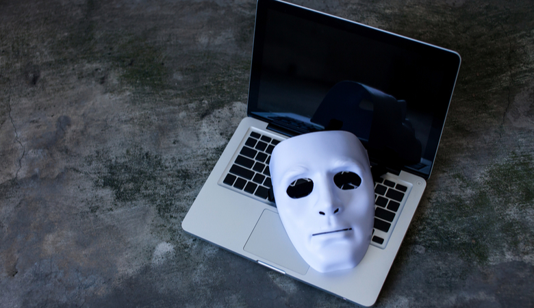 Anonymous mask to hide identity on computer laptop fraud concept