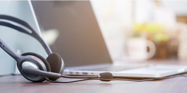 close up soft focus headphone call centre hotline at computer office help desk for background concept.