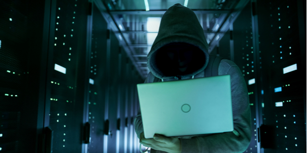 Close-up shot of hacker in a data center full of rack servers